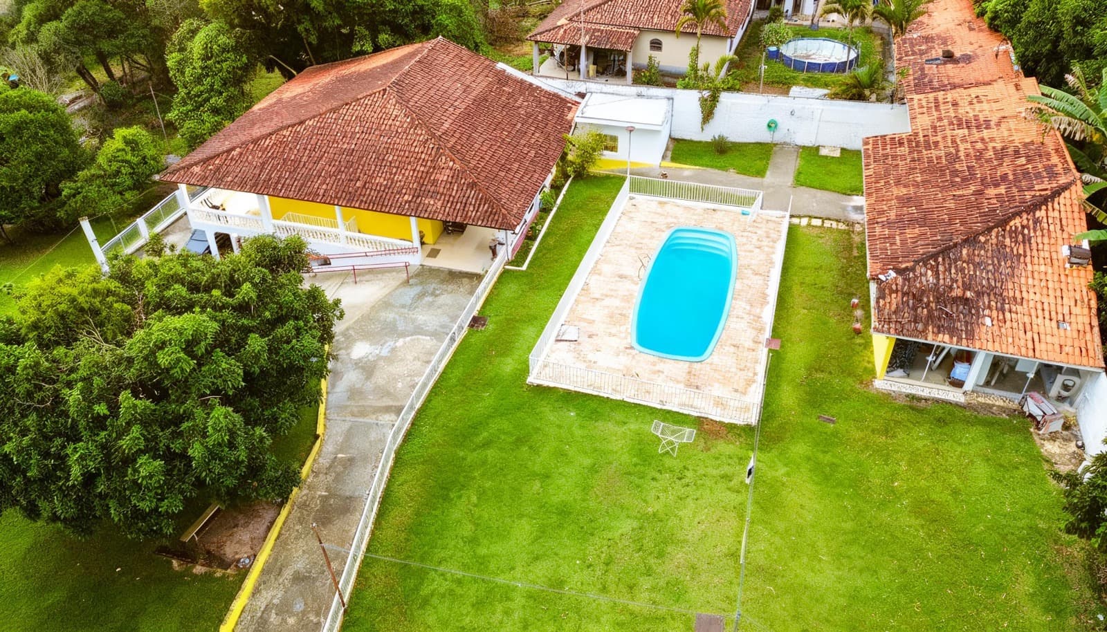 Vista aérea da propriedade Arhat com piscina, construções e áreas verdes.