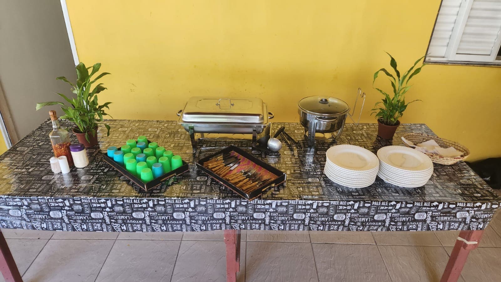 Mesa de apoio com recipientes de alimentos, pratos e utensílios.